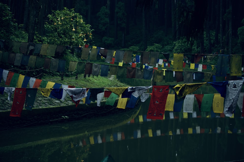 a stream of water with a bunch of colorful flags hanging from it