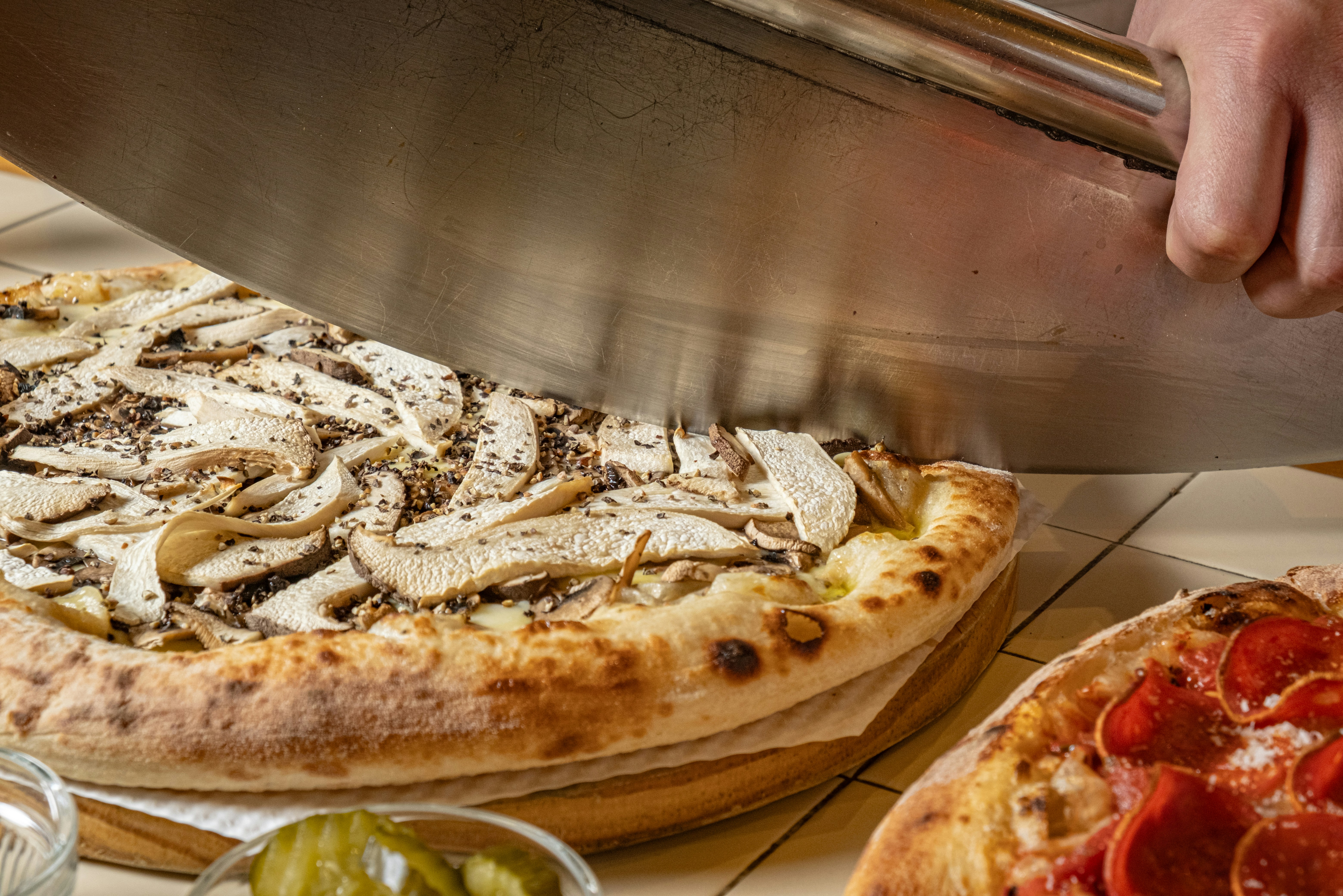 A small pizza being lifted from a board
