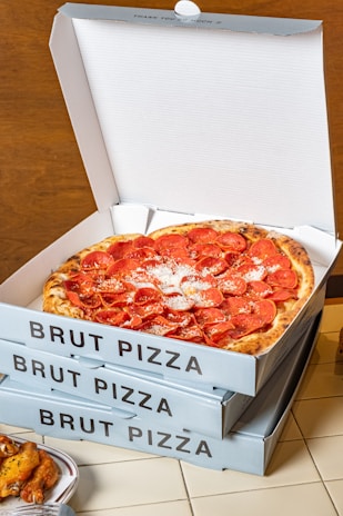a pizza sitting inside of a pizza box on top of a table