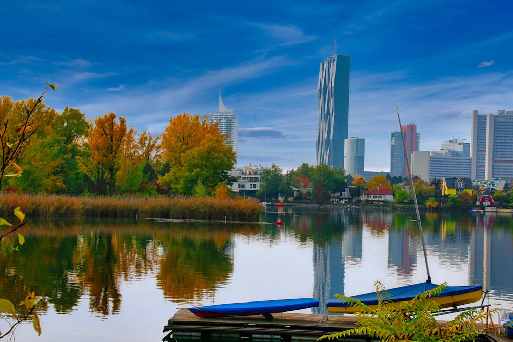 a lake with a few boats on it and a city in the background