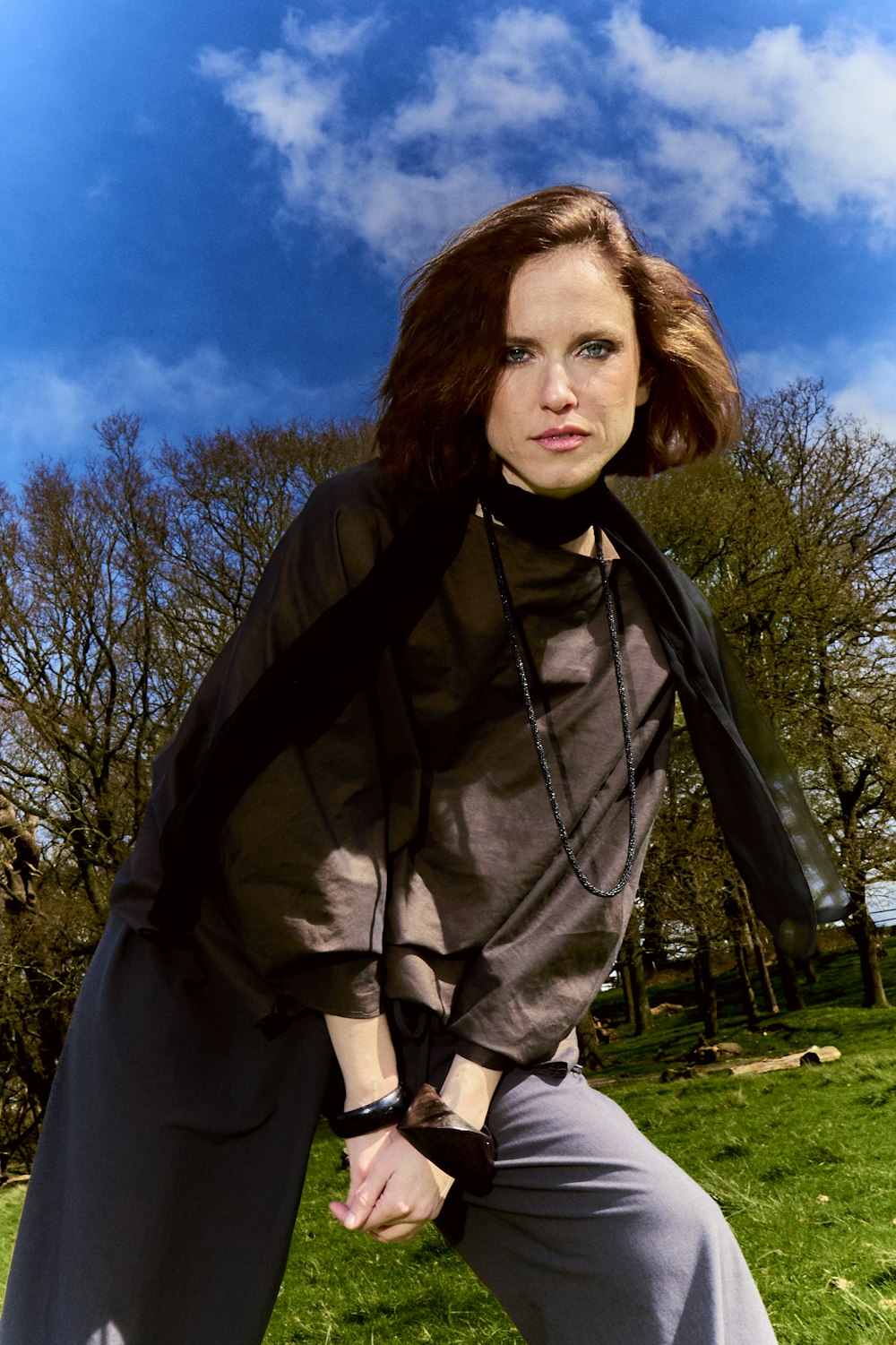 a woman is posing for a picture in the grass