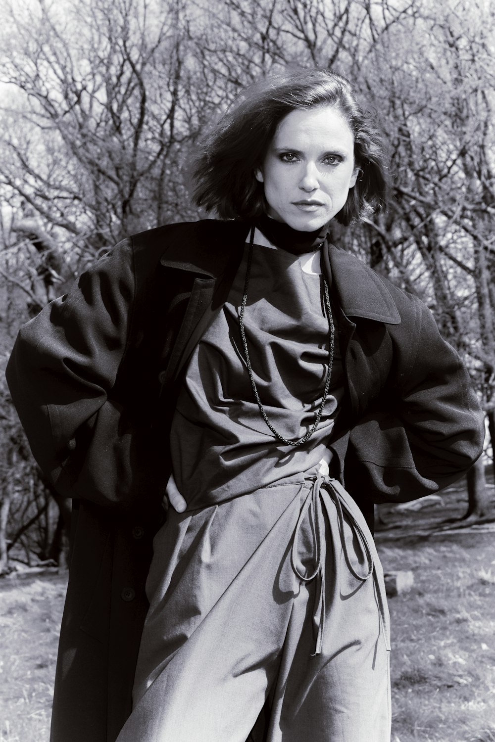 a black and white photo of a woman in a park