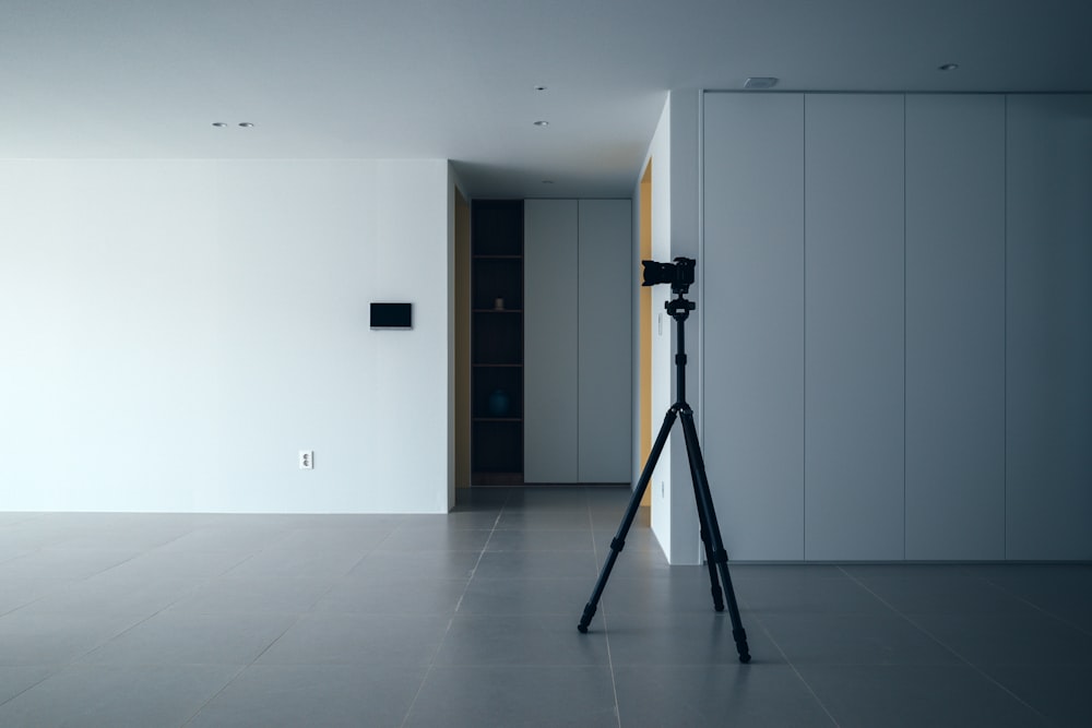 an empty room with a camera on a tripod