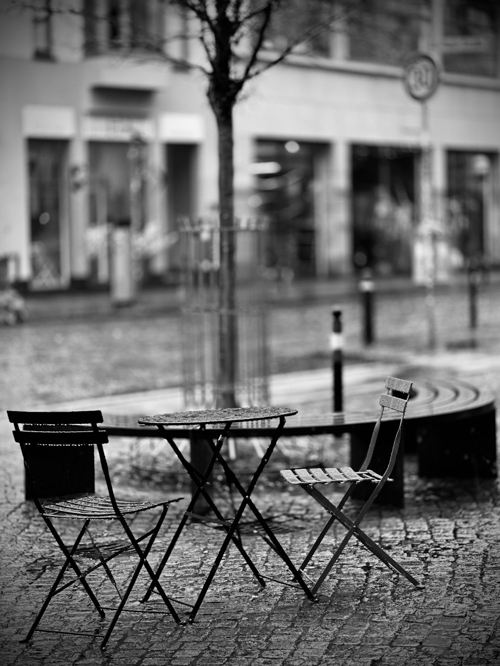 two chairs and a table on a cobblestone street