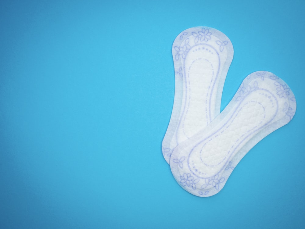 a pair of sanitary pads sitting on top of a blue surface