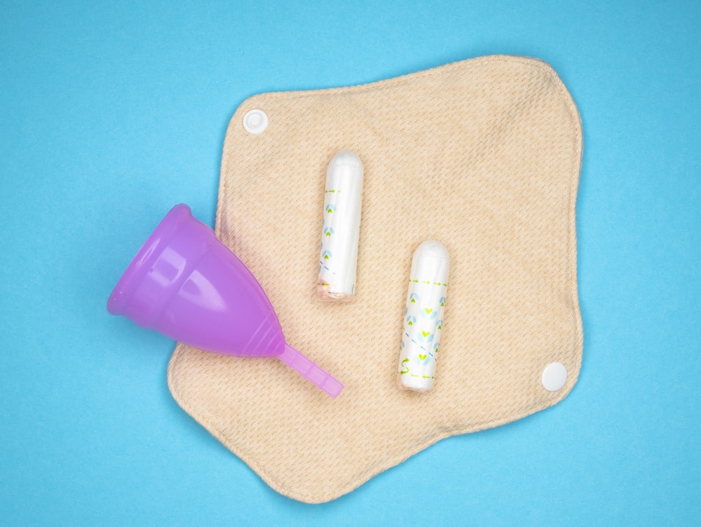 two toothbrushes and a purple cup on a blue background