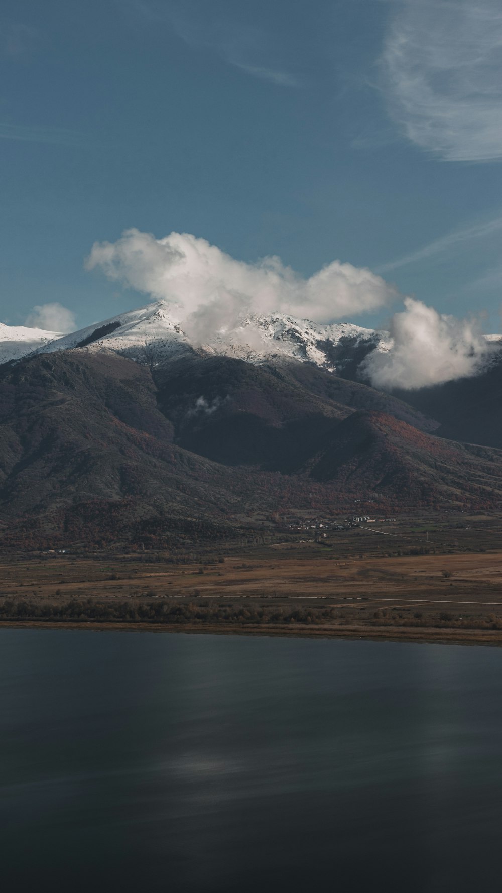 a large body of water with a mountain in the background