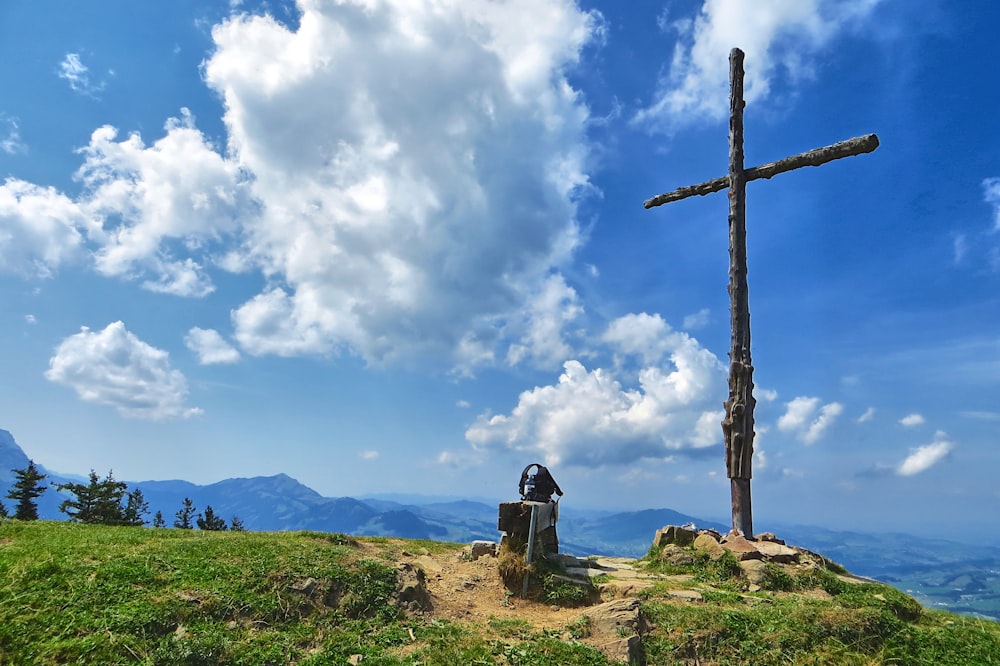 a cross on top of a hill with a sky background