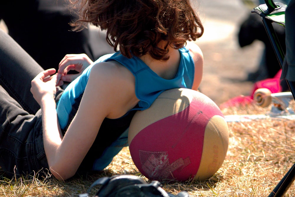 공을 들고 땅에 앉아있는 어린 소녀