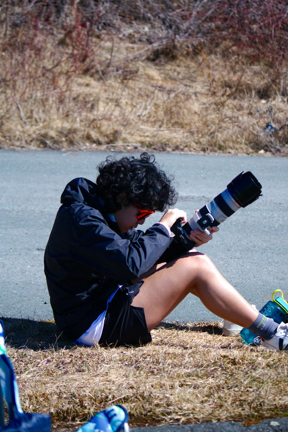 a person sitting on the ground with a camera