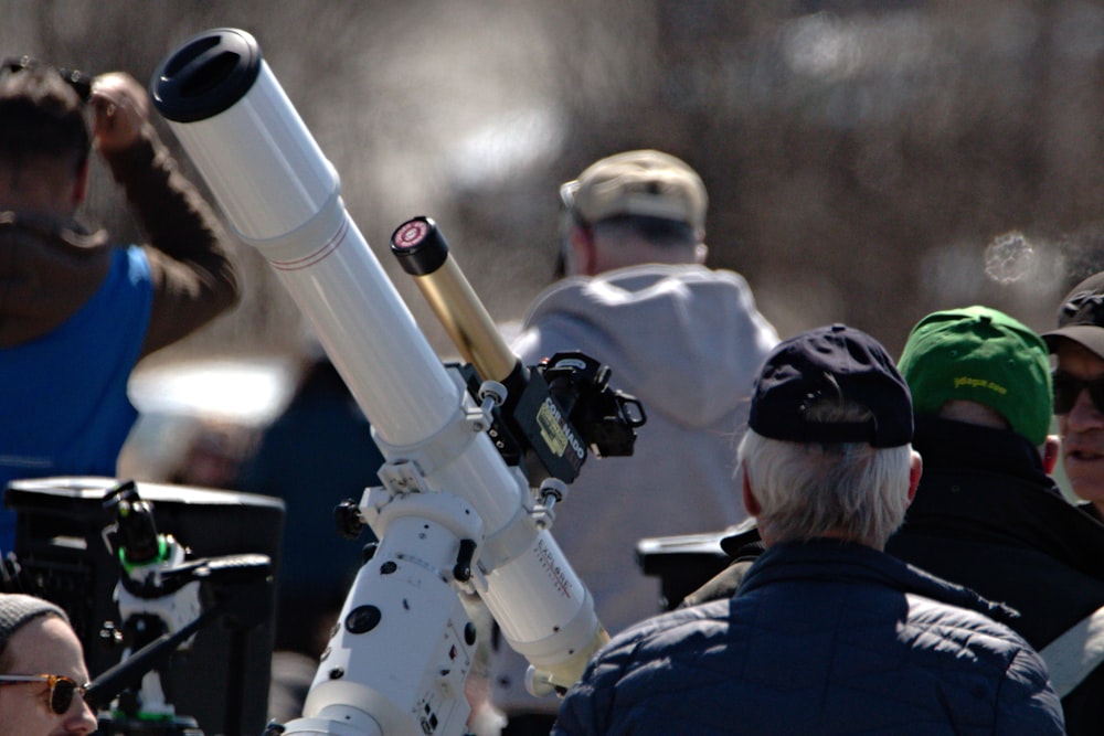 a group of people standing around a telescope