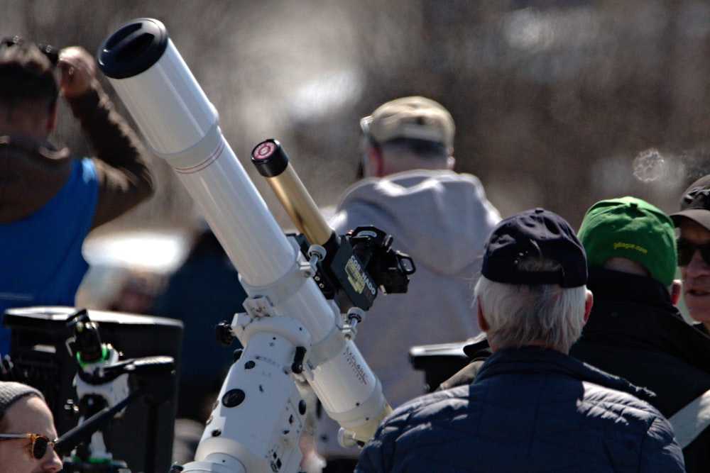 un gruppo di persone in piedi intorno a un telescopio