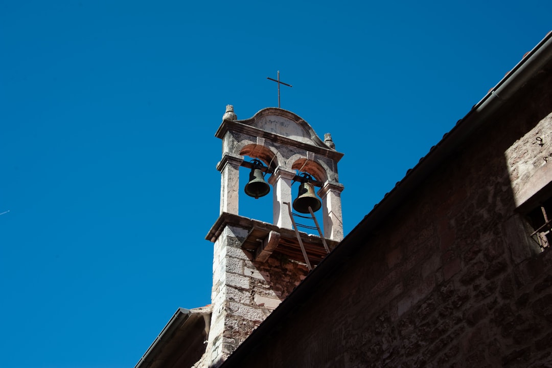 a bell tower with two bells on top of it,