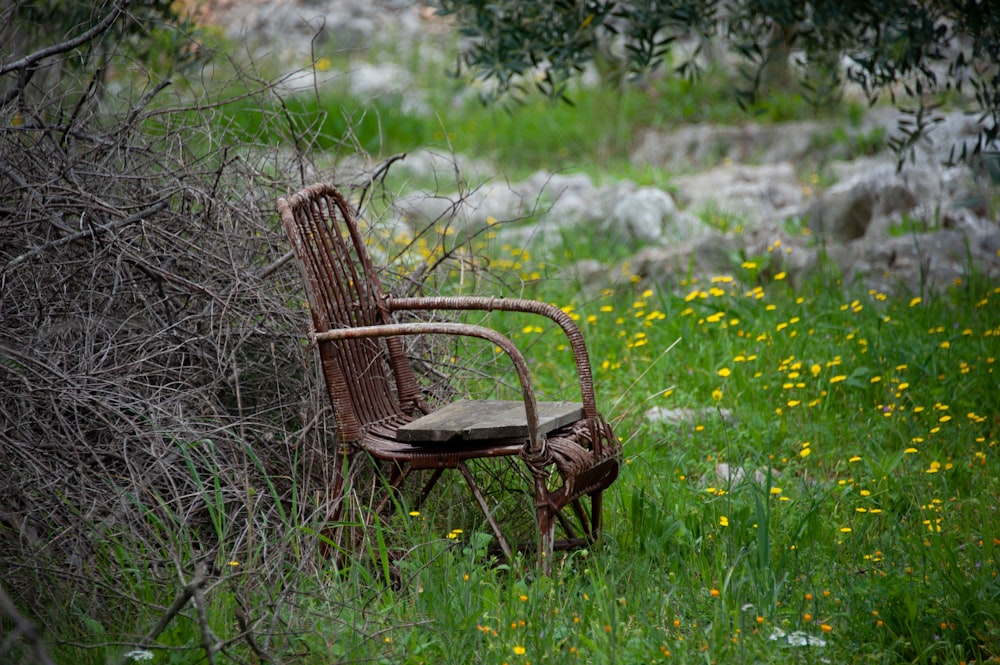 an old chair sitting in the middle of a field
