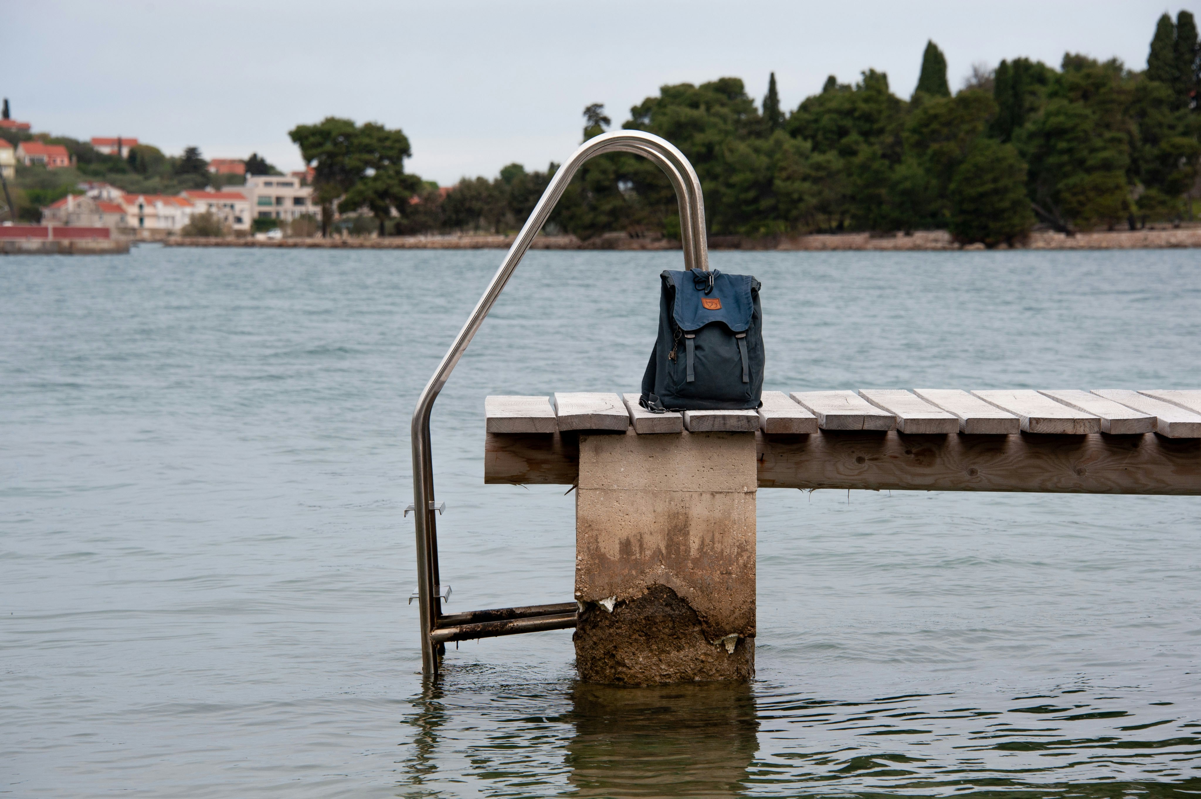 a blue bag sitting on top of a wooden dock, 
