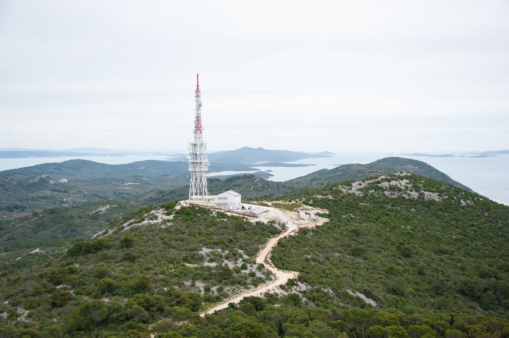 una torre molto alta che si trova in cima a una collina verde e lussureggiante