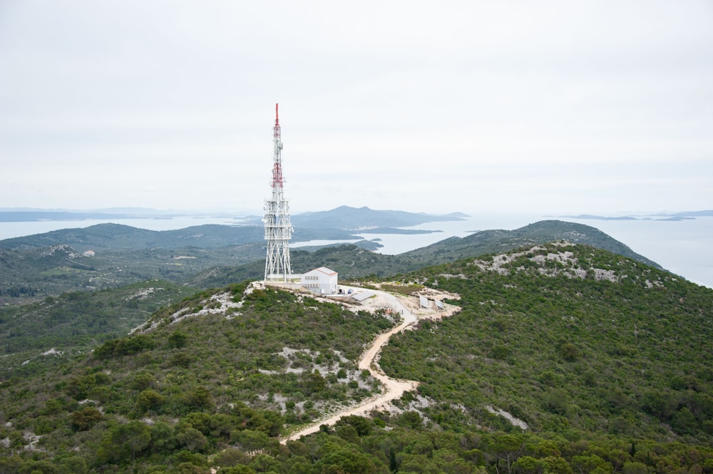 una torre muy alta asentada en la cima de una exuberante ladera verde