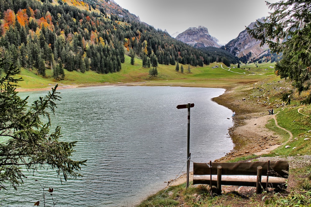 a bench sitting on the shore of a lake