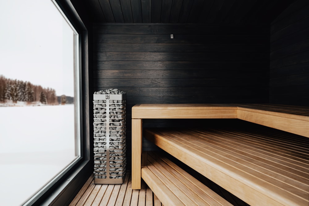 a wooden bench sitting next to a window