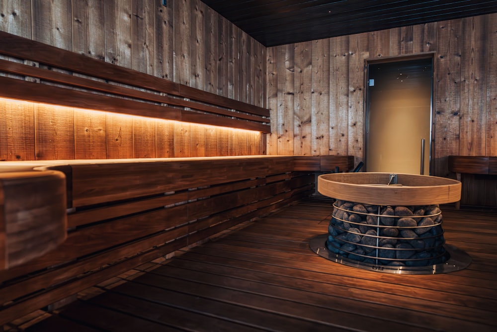 a wooden room with benches and a round table