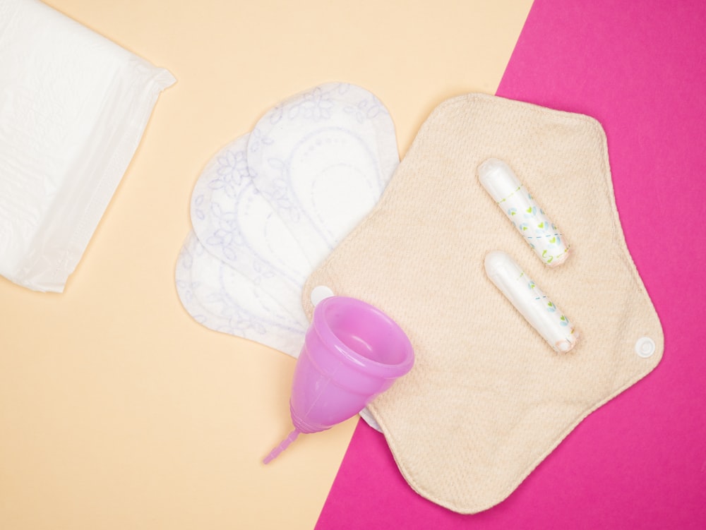 a pink and yellow table topped with a baby bottle and a diaper