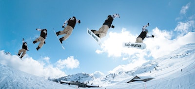 a man flying through the air while riding a snowboard