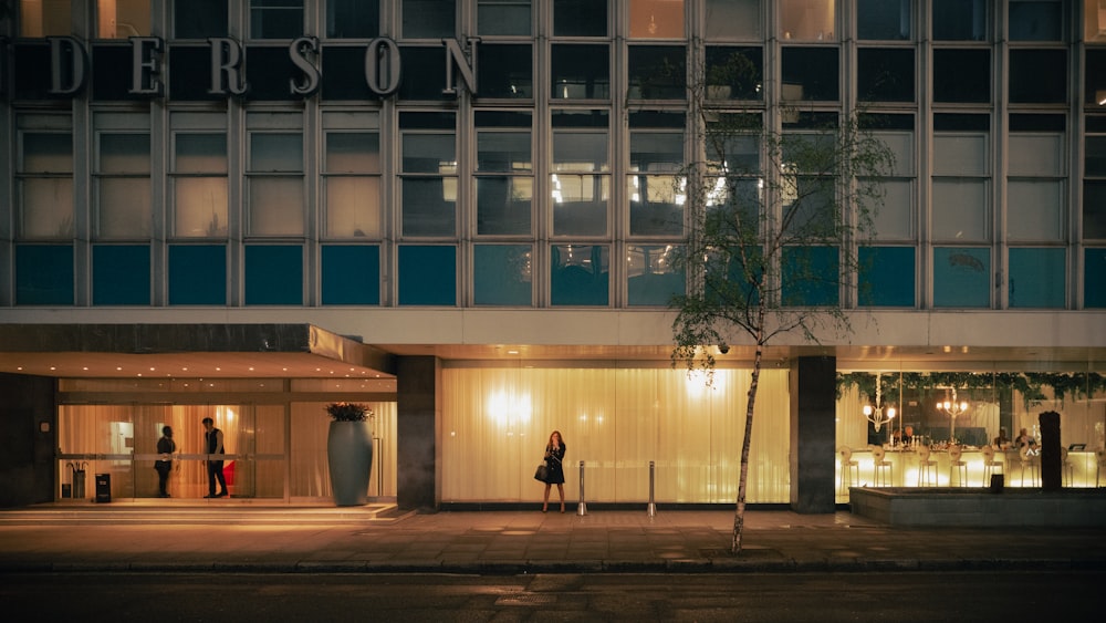 a person standing outside of a building at night