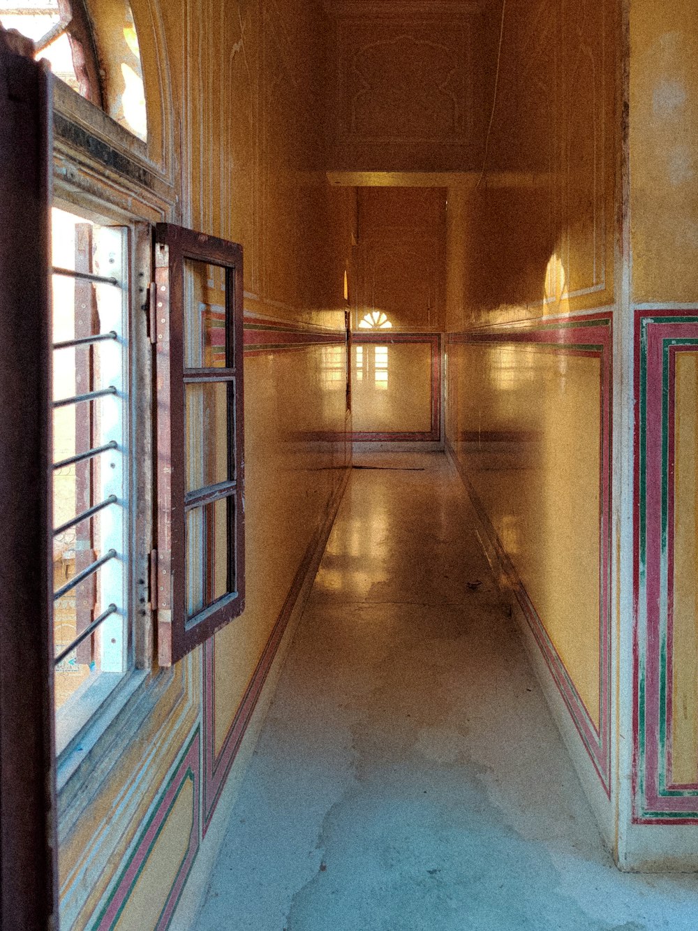 a long hallway with a window and a clock on the wall