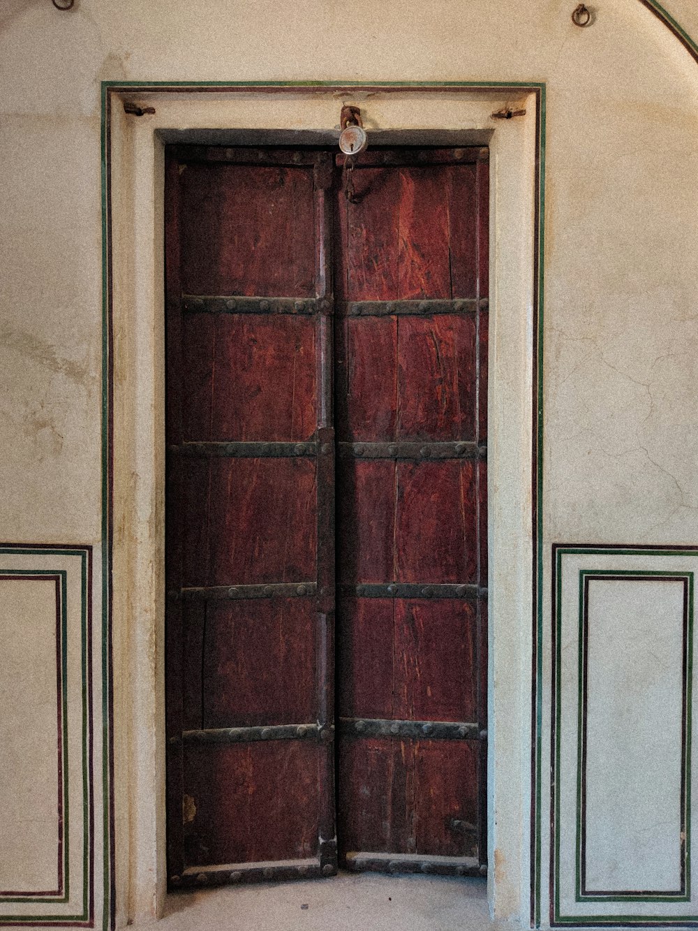 a large wooden door in a white wall