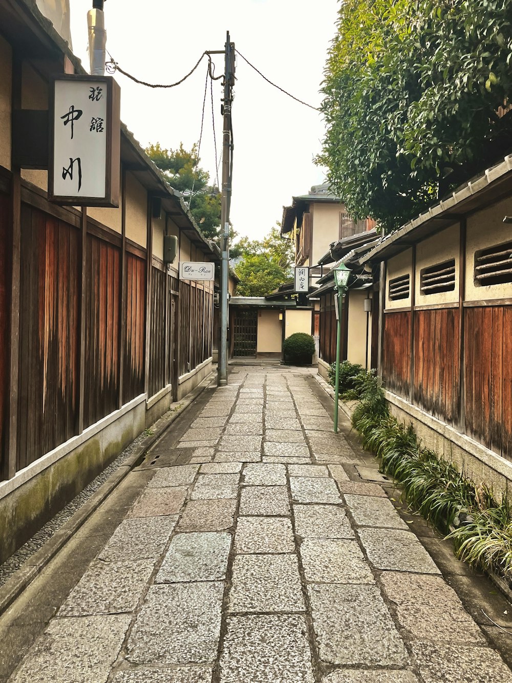 una calle estrecha con un letrero a un lado