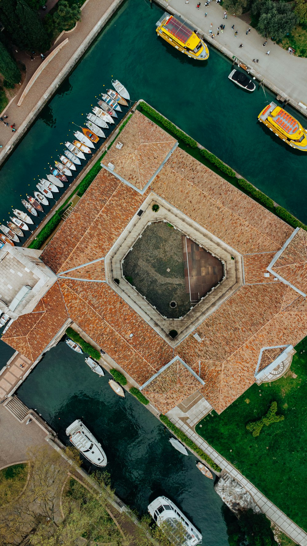 an aerial view of a parking lot next to a body of water