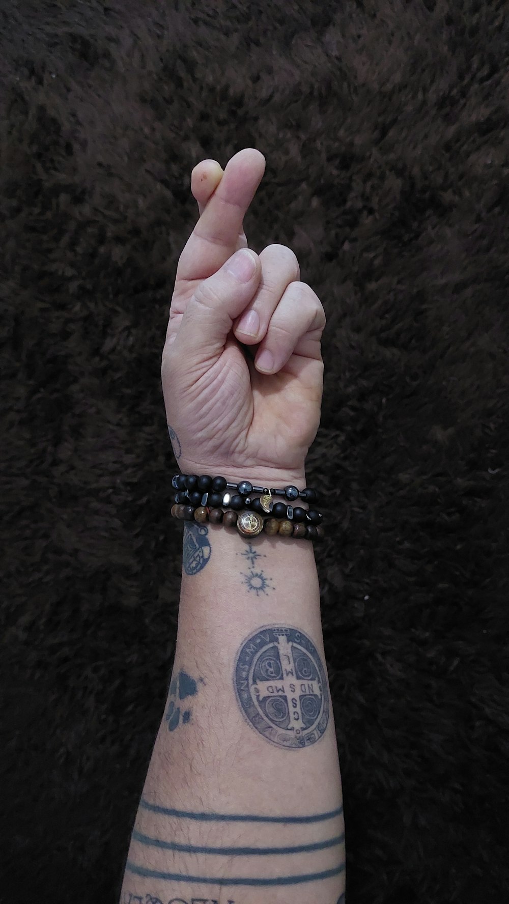 a man with a tattoo on his arm making the peace sign
