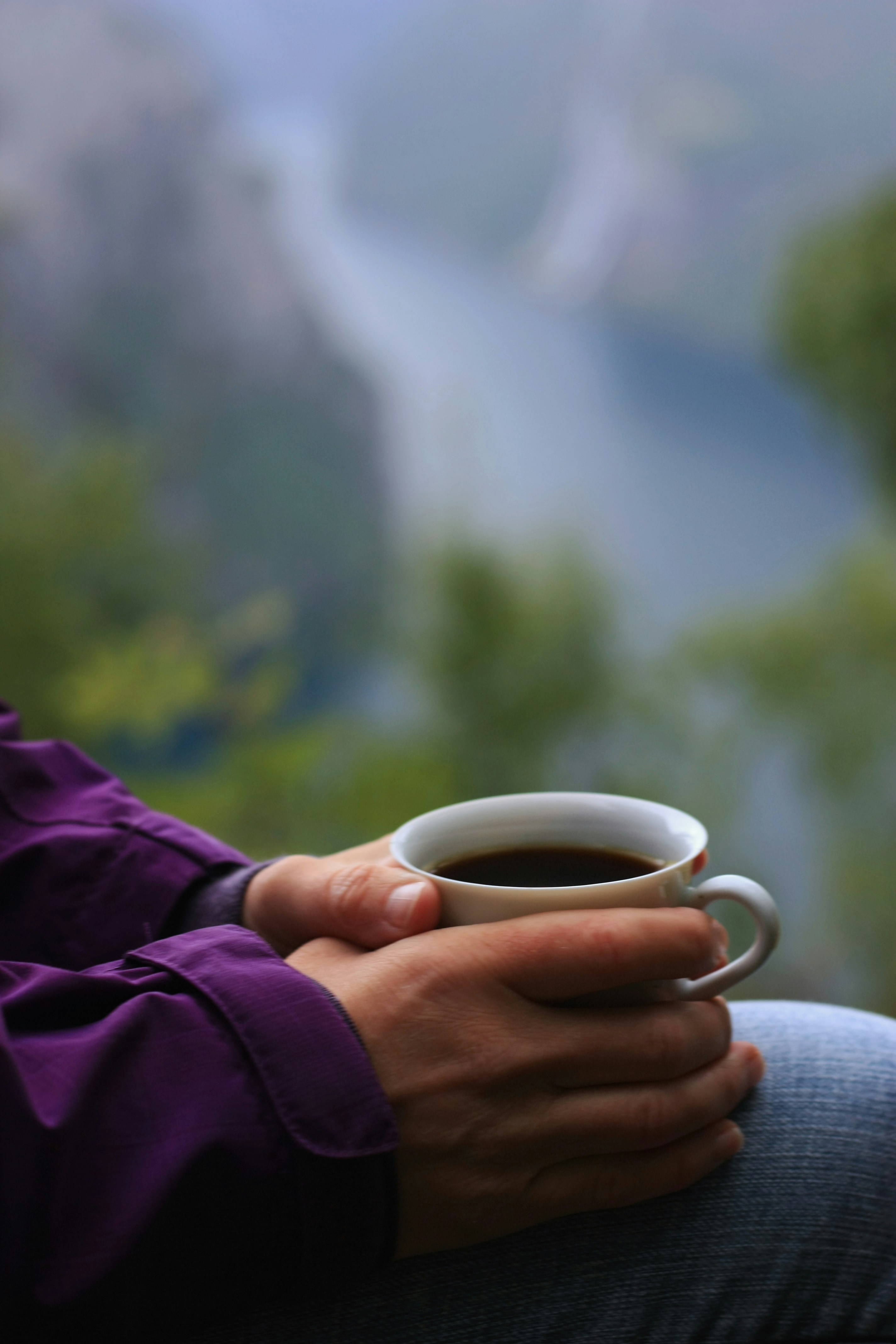 a person holding a cup of coffee in their hands