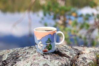 a cup of coffee sitting on top of a rock