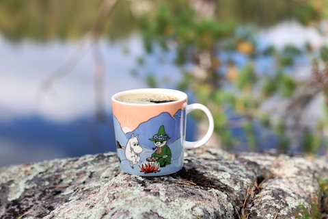 a cup of coffee sitting on top of a rock