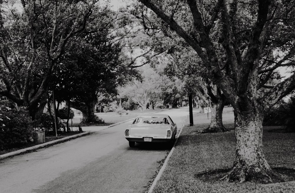 a black and white photo of a car parked on the side of the road