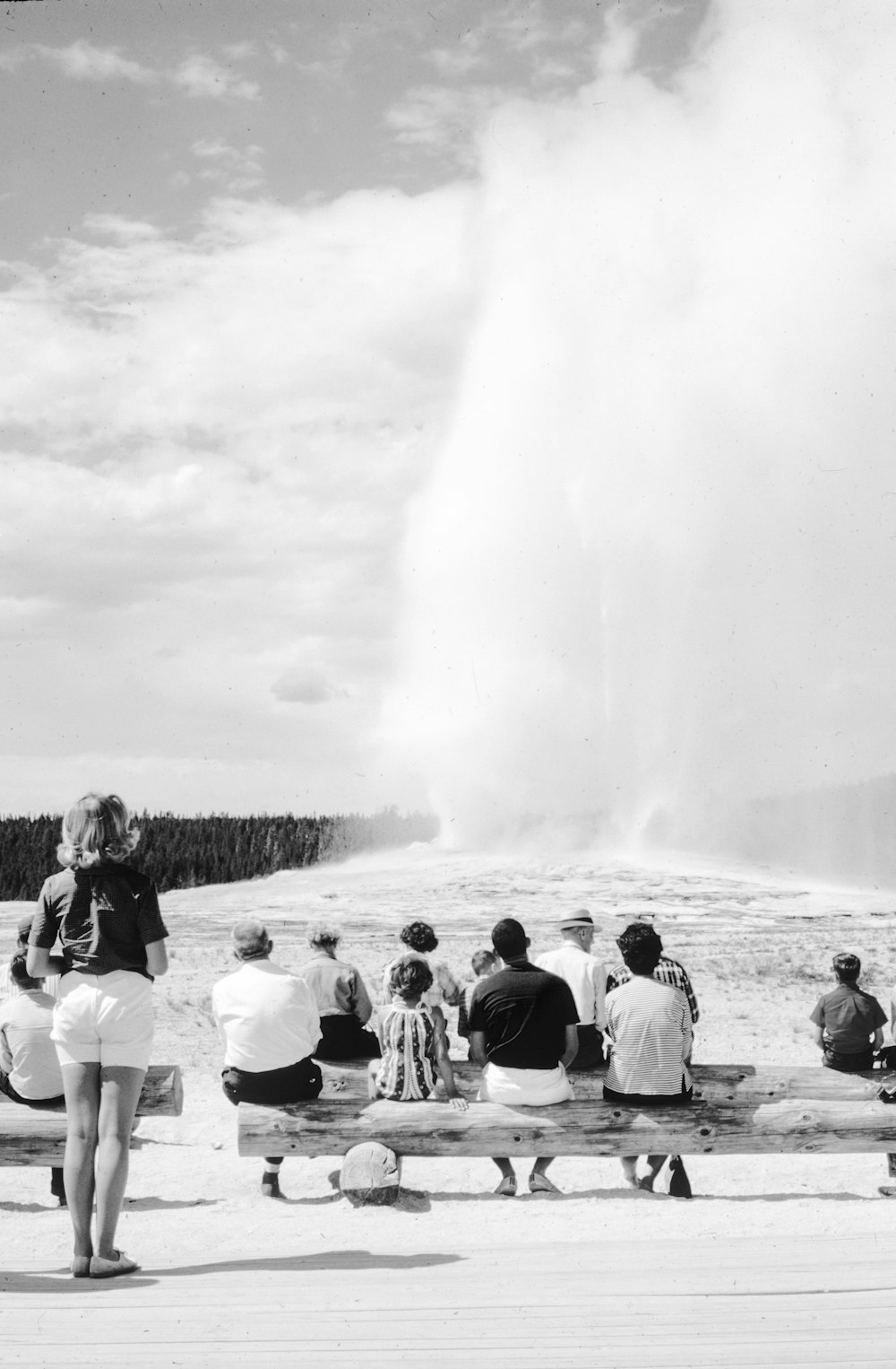 a group of people sitting on top of a wooden bench