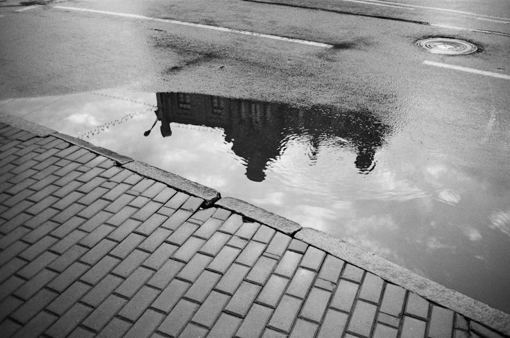 a reflection of a building in a puddle of water