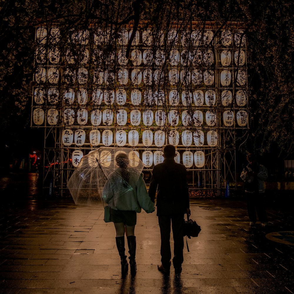 a man and a woman standing in front of a wall of lights
