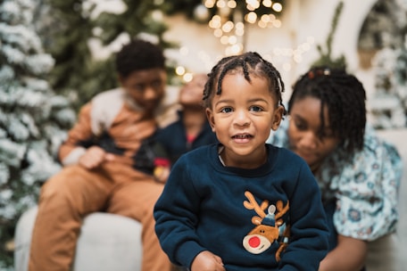 a little boy sitting on a couch with his family