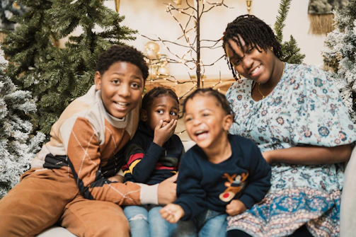 a family sitting on a couch in front of a christmas tree