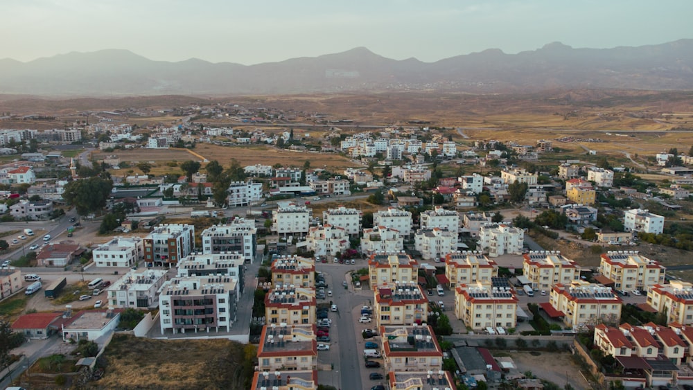 an aerial view of a city with mountains in the background