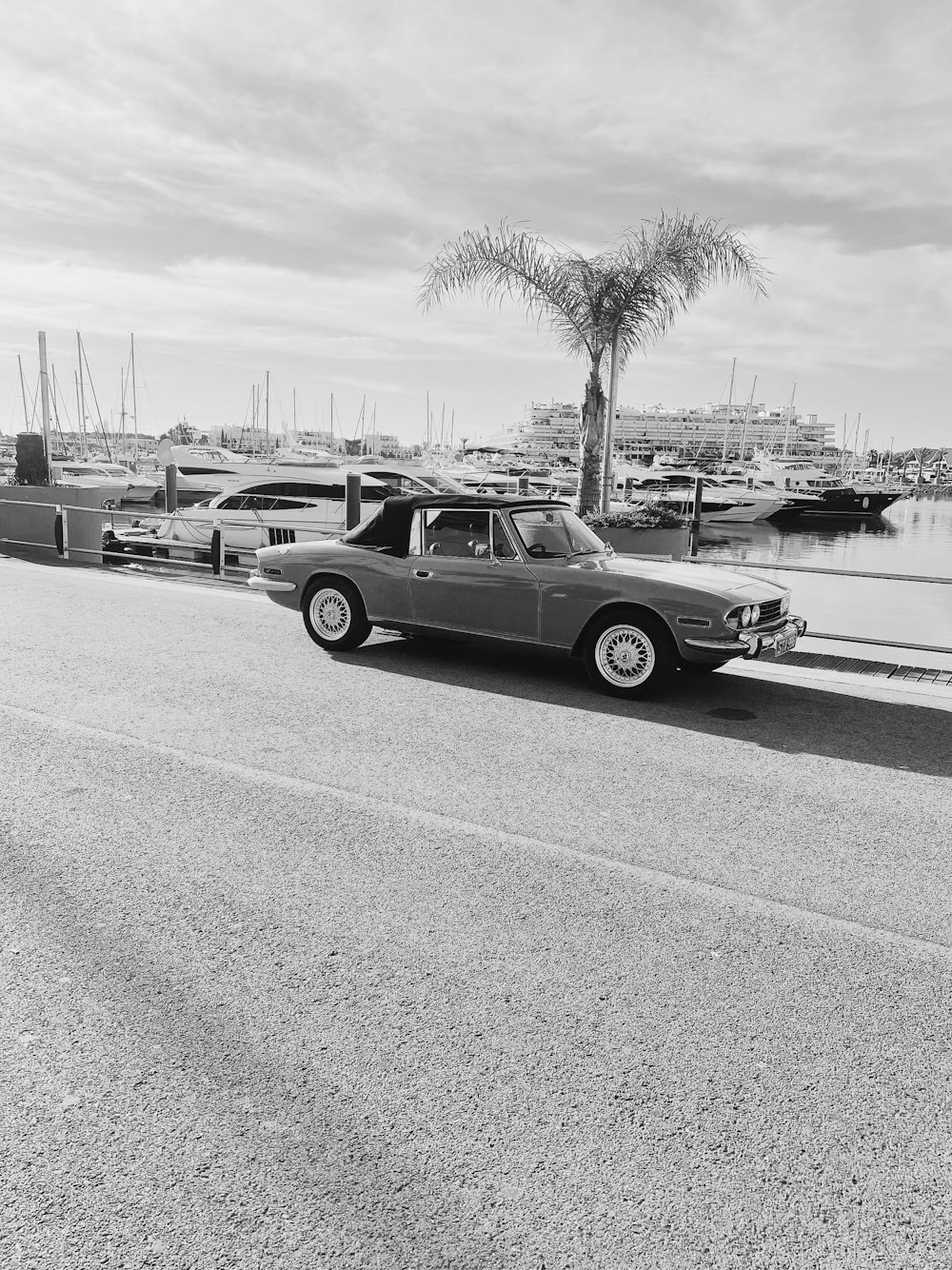 a black and white photo of a car parked on the side of the road