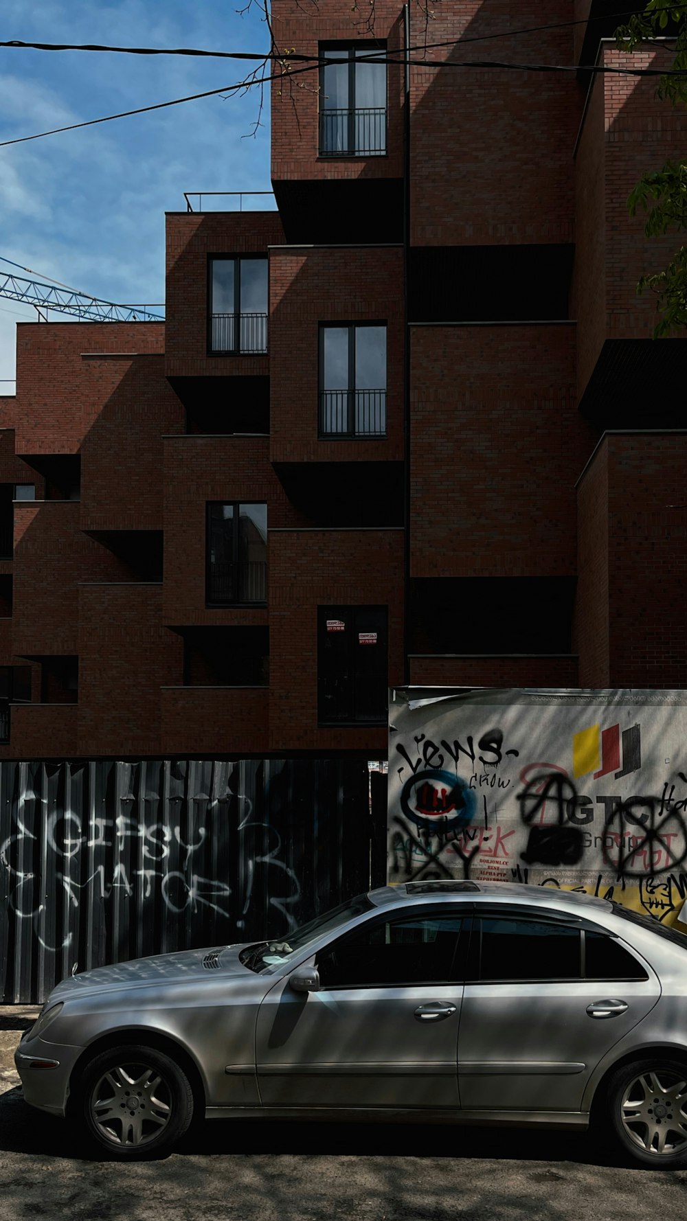 a car parked in front of a building with graffiti on it