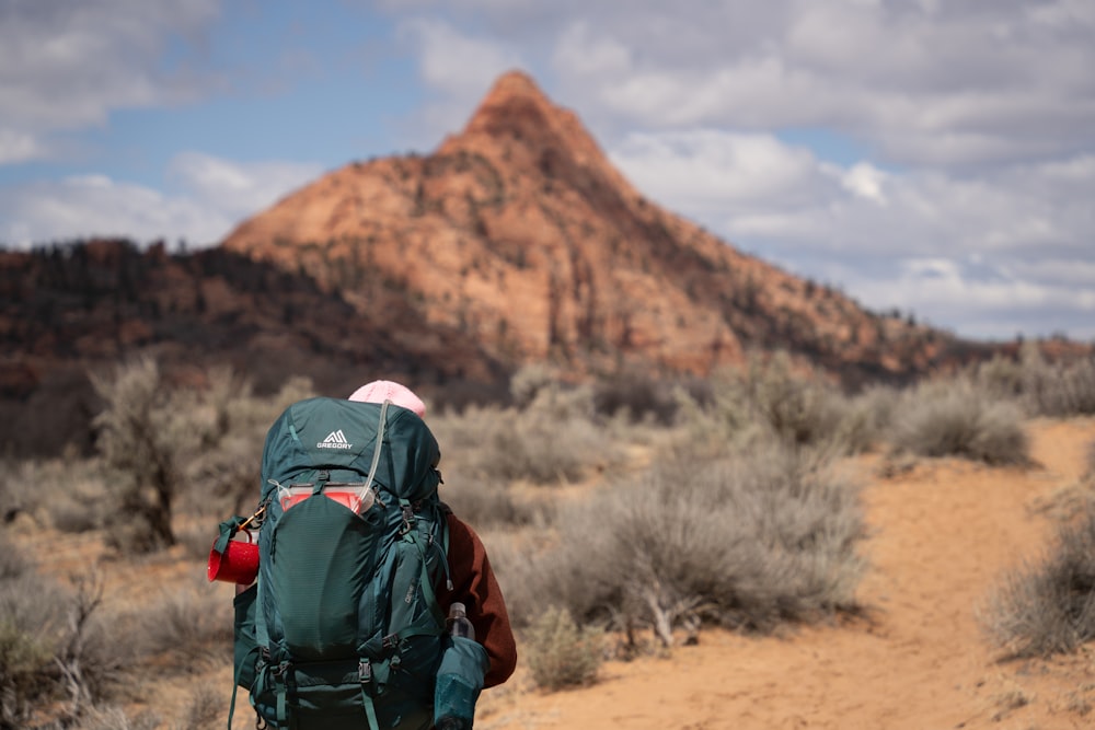 a person with a backpack walking on a dirt path