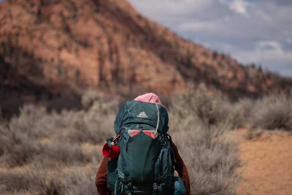 a person with a backpack walking in the desert