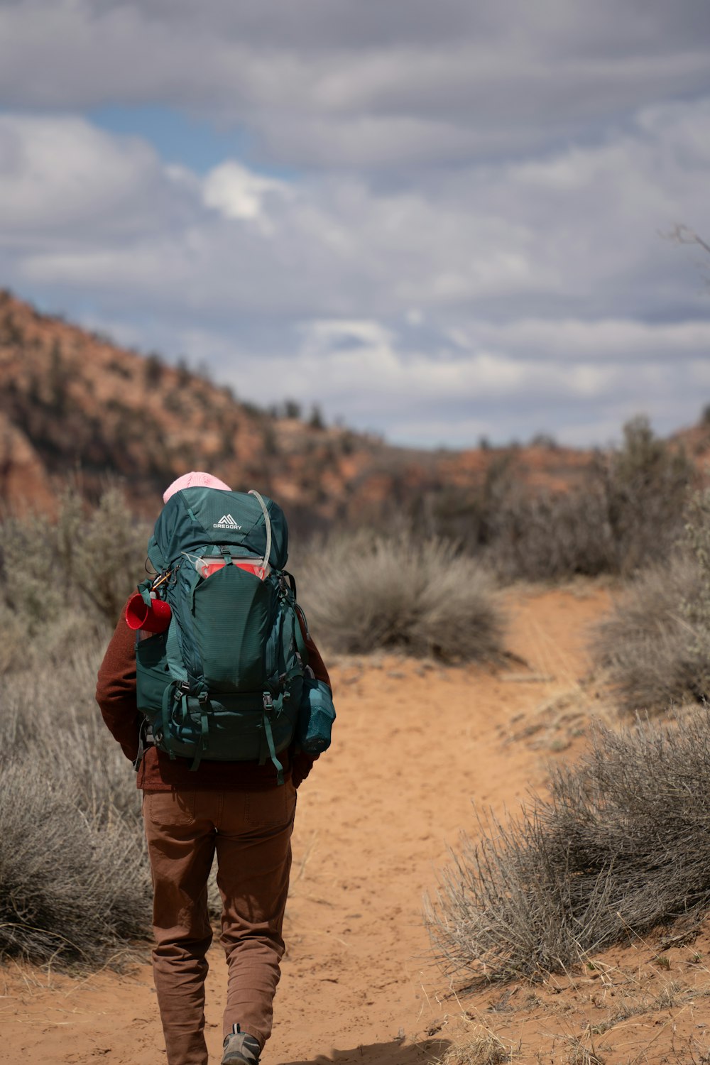 a person with a backpack walking in the desert