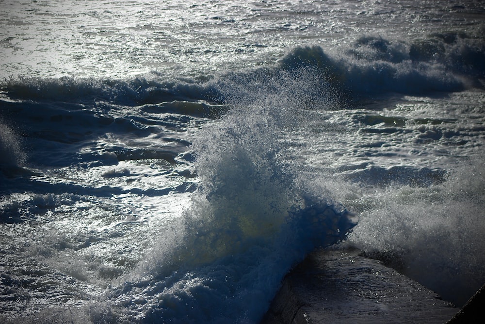 a wave crashing into the shore of a body of water