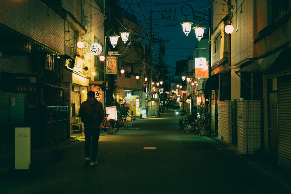 a person walking down a street at night