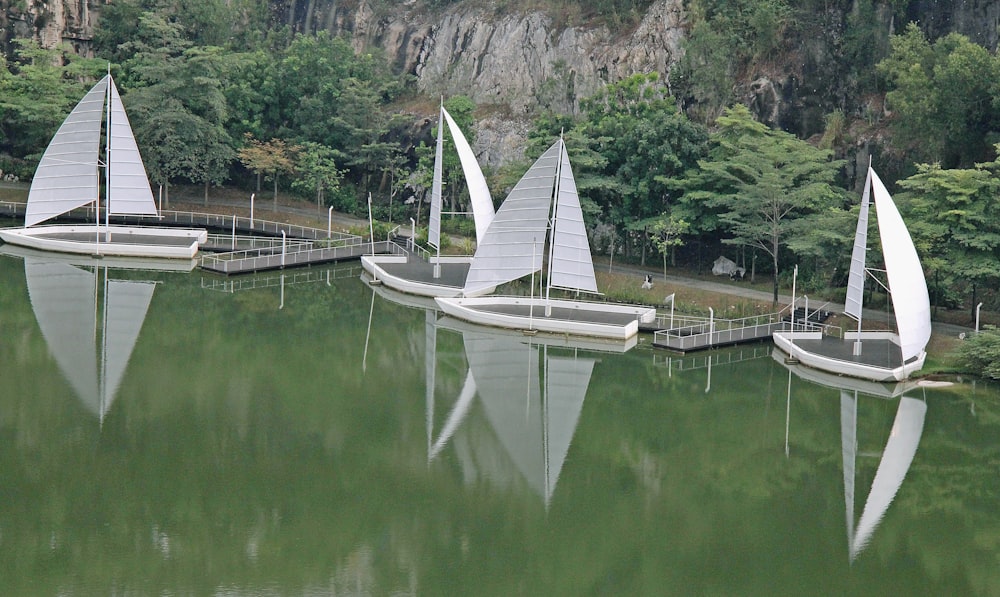 a group of sail boats floating on top of a lake